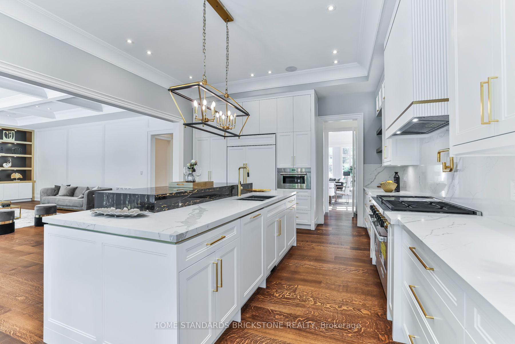 White custom kitchen with brass hardware and marble island